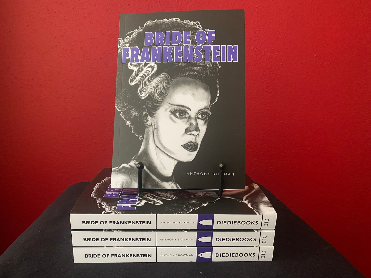 Stack of Bride of Frankenstein books by Anthony Bowman. Front cover illustration of the Bride is white on black background. Side cover is black text on white background.
