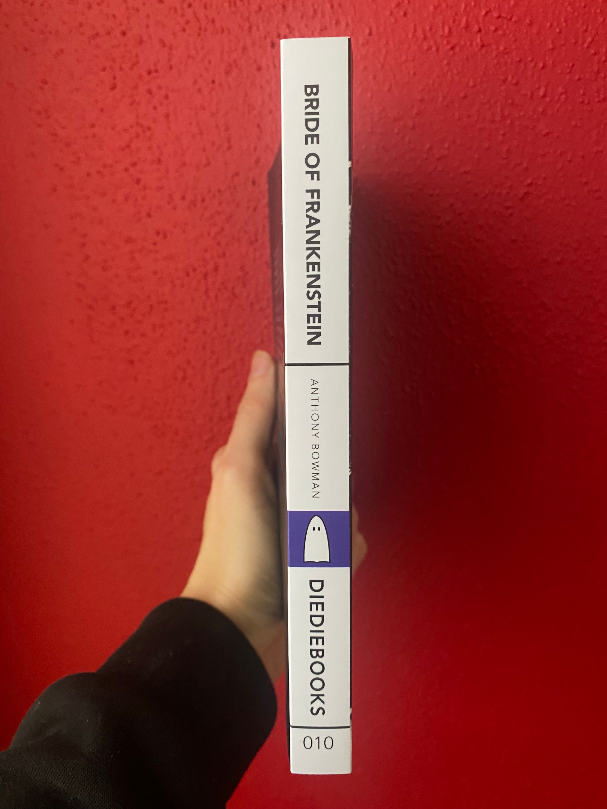 Side view of the DieDieBook Bride of Frankenstein by Anthony Bowman. White spine with black text. 